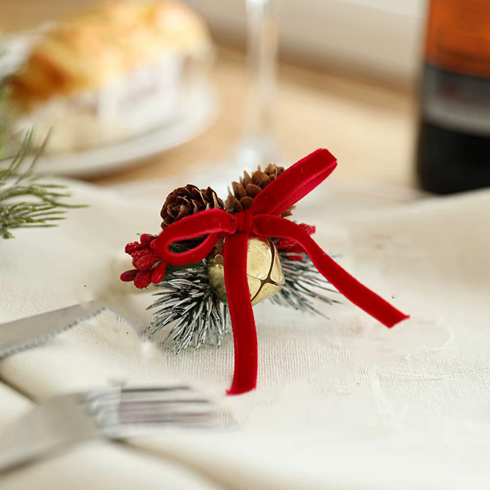 Anneau de serviette en forme de cloche de noël, nœud papillon, festif avec pomme de pin de fruits ro